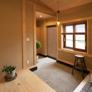 山を背にした、薪ストーブのある平屋