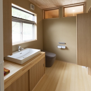 山を背にした、薪ストーブのある平屋